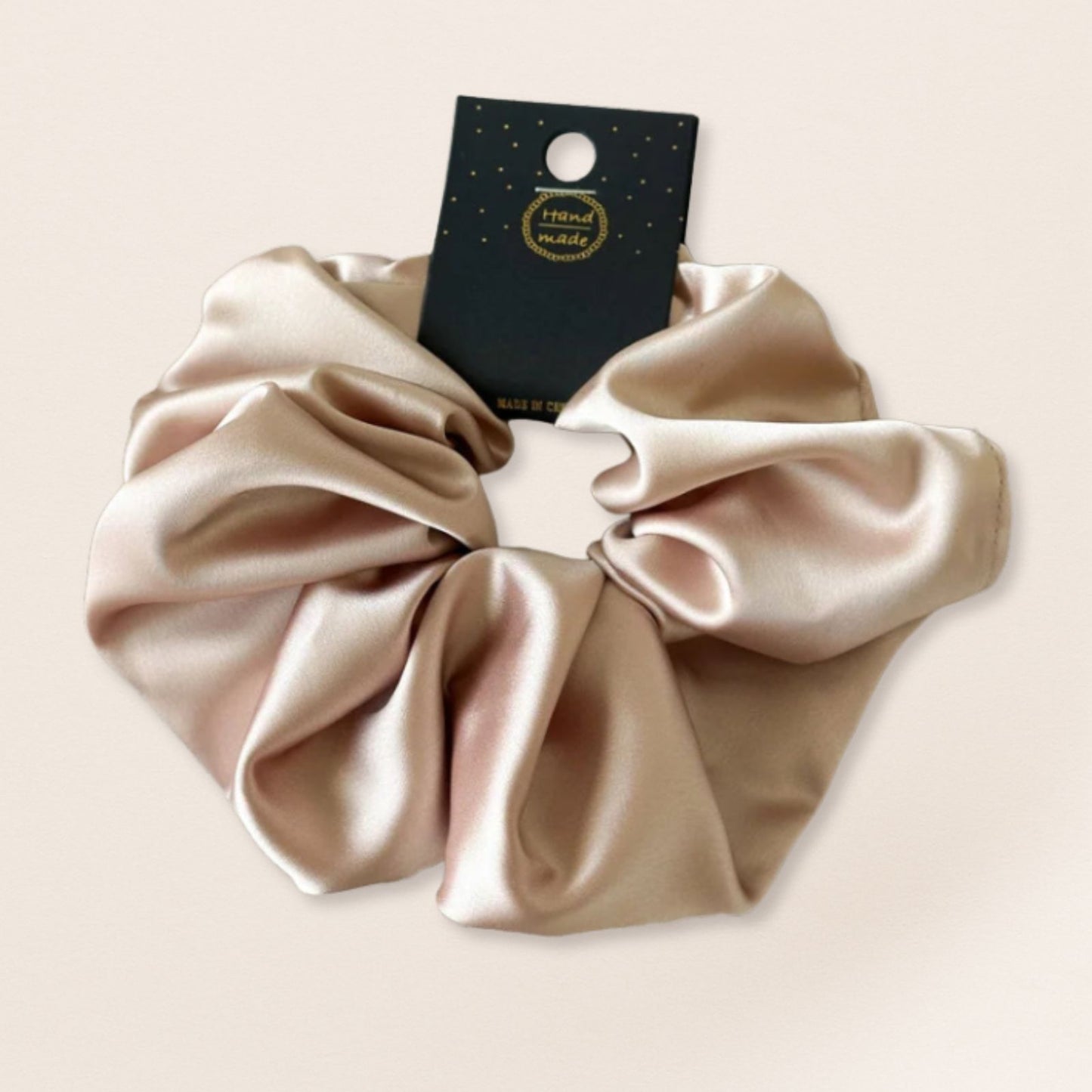 Beige satin scrunchie for fine hair on a beige background