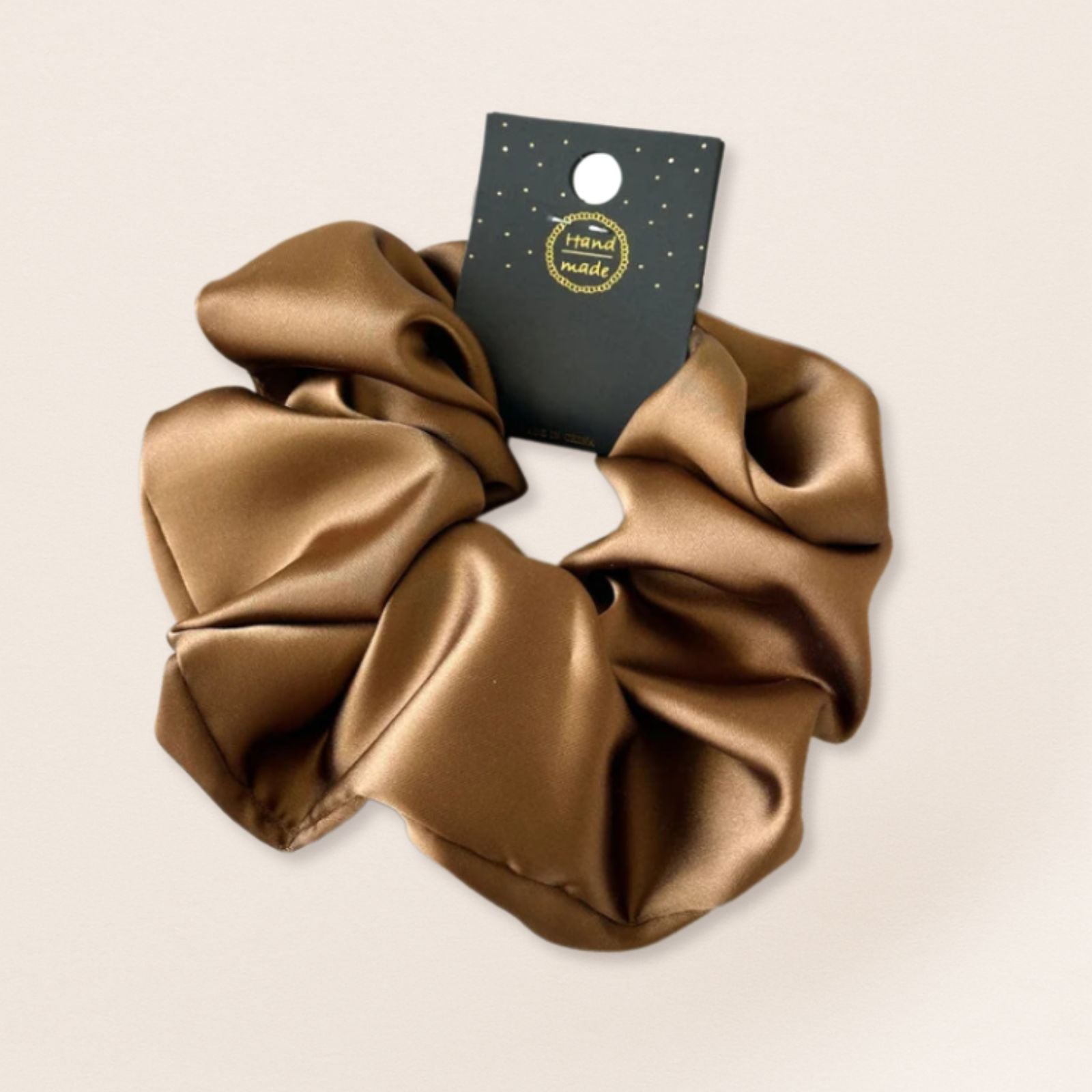 Bronze scrunchie for fine hair on a beige background
