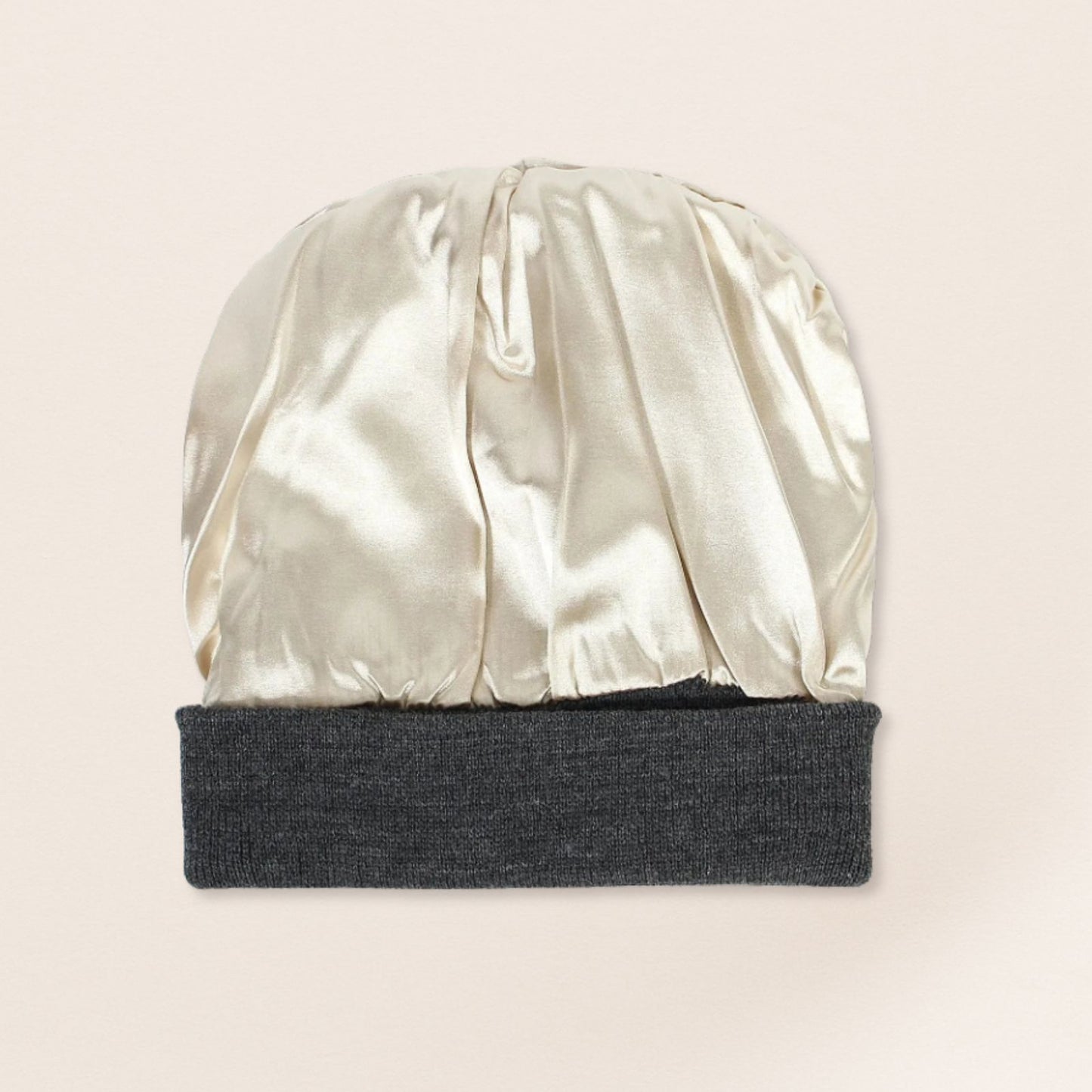 Two-toned beanie with satin interior and knit top on a beige background