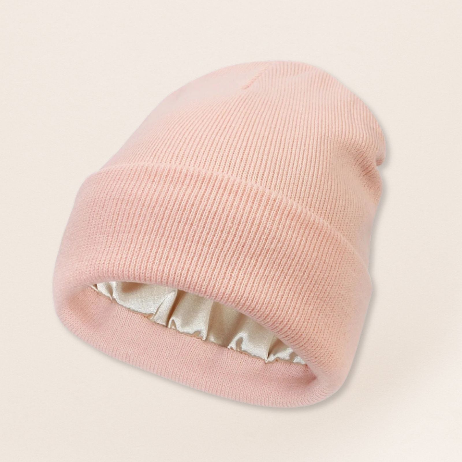 Light Pink beanie with satin interior on a beige background