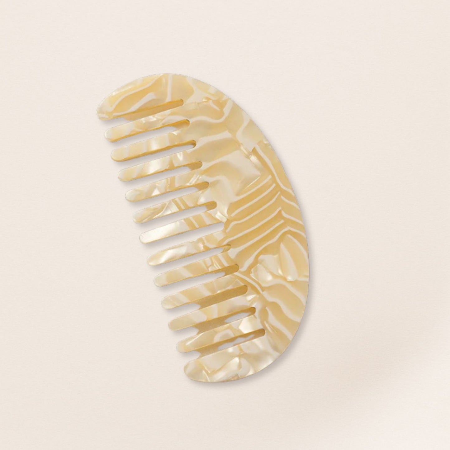 Lightweight cream marbled half-moon comb for fine hair on a beige background.