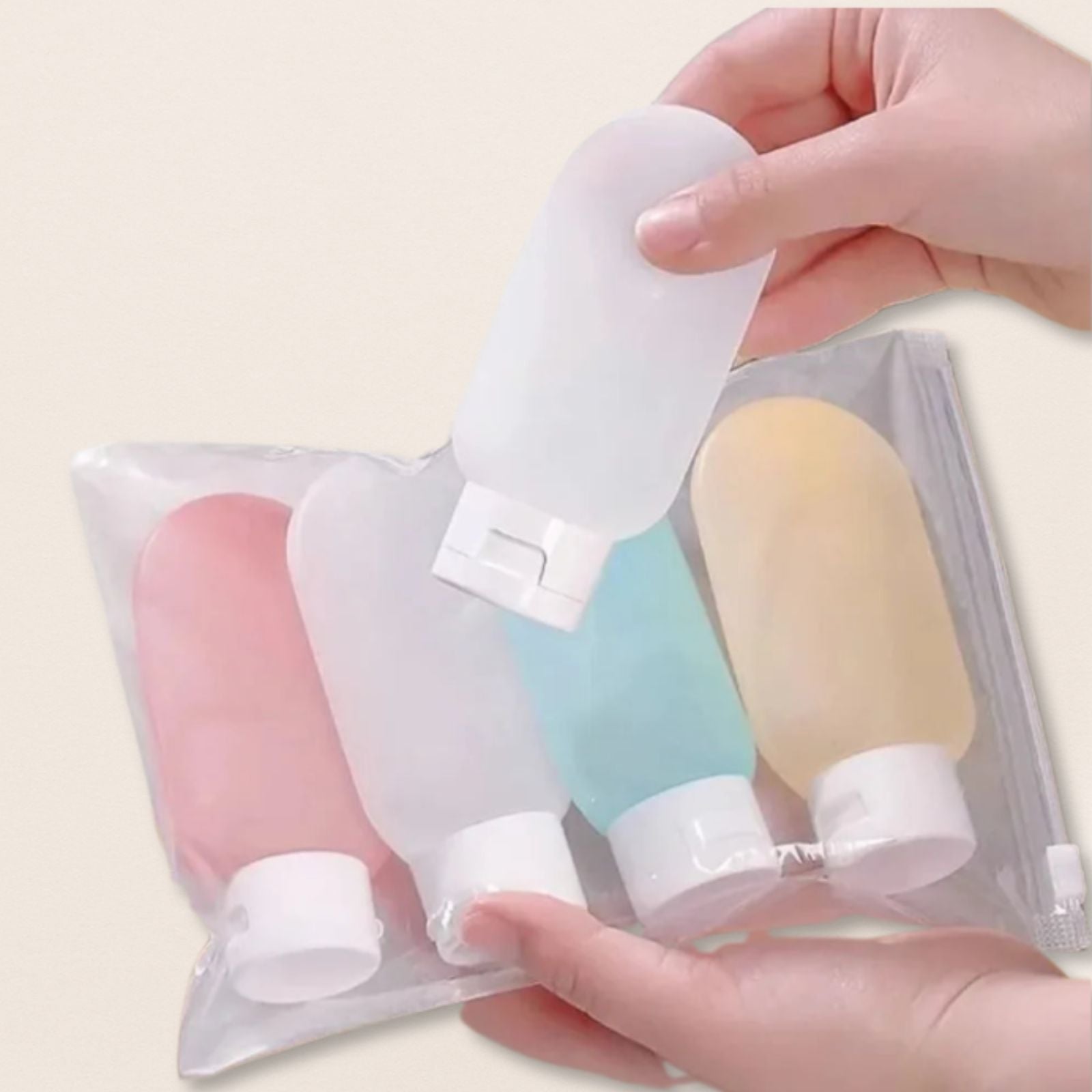 Set of small travel bottles with colourful caps held by a hand against a light background