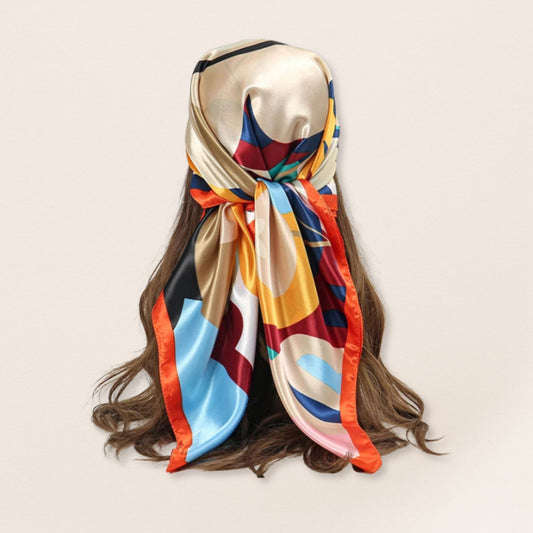 Mannequin head with colourful scarf draped over hair on a beige background