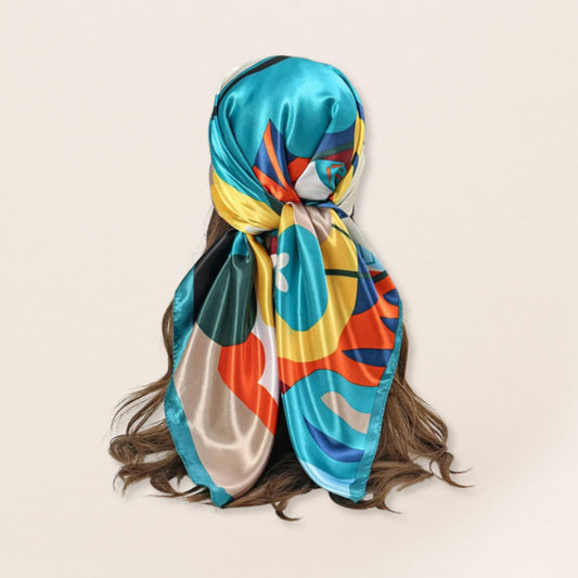 Colourful patterned headscarf on a person with a beige background