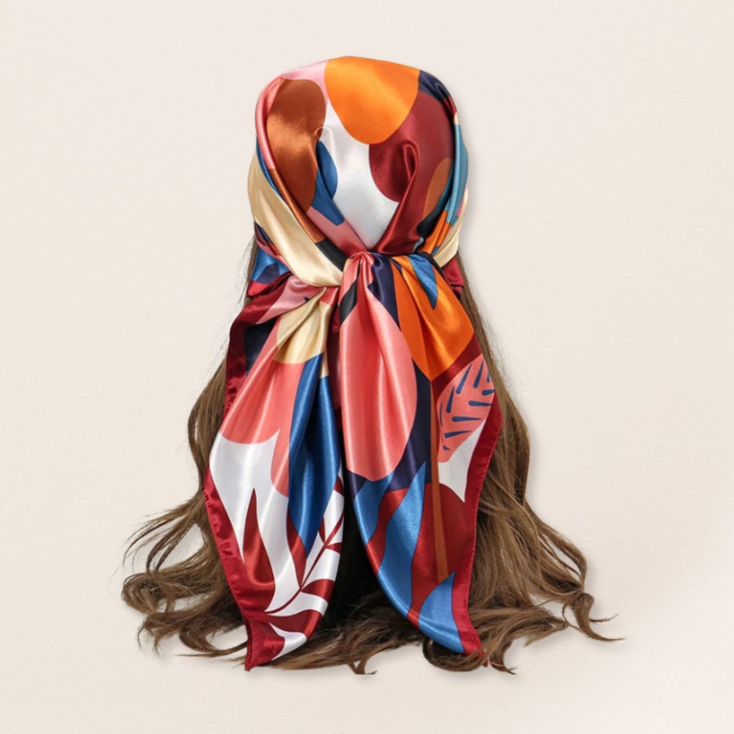 Colourful scarf tied around a person's head with a beige background