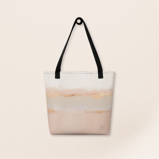 Beige and blush abstract tote bag with gold brushstroke accents and black handles on a beige background.