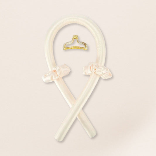 Ivory heatless curling set with satin scrunchies and a gold clip on a beige background.