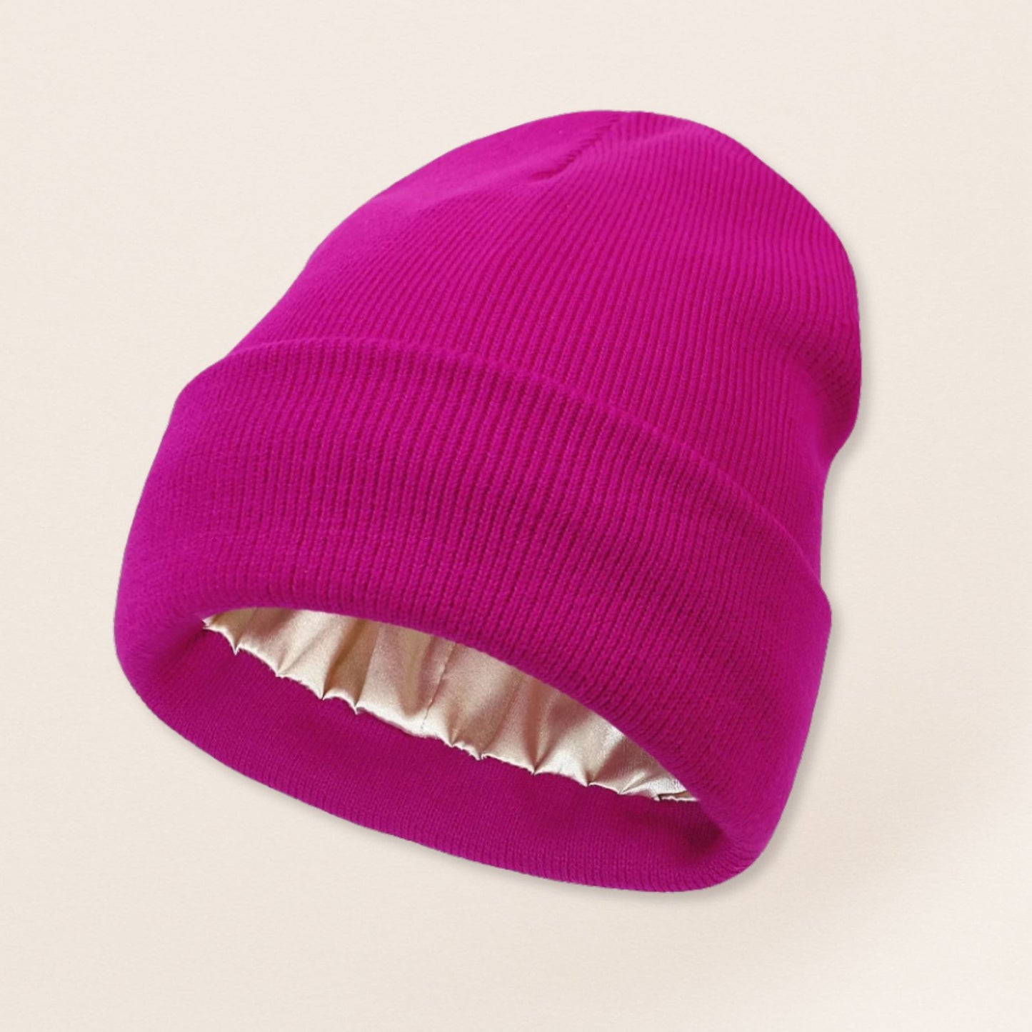 Pink beanie with satin interior on a beige background