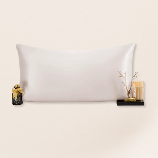 White pillow on a beige background with decorative items on either side