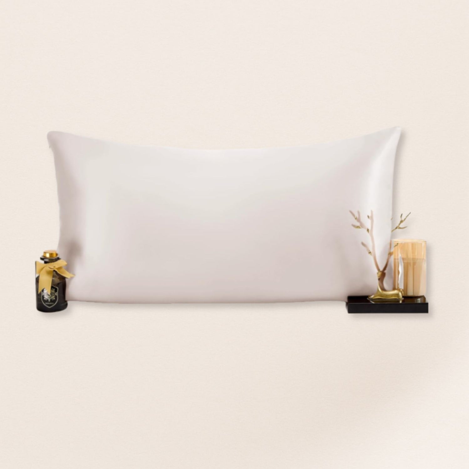 White pillow on a beige background with decorative items on either side