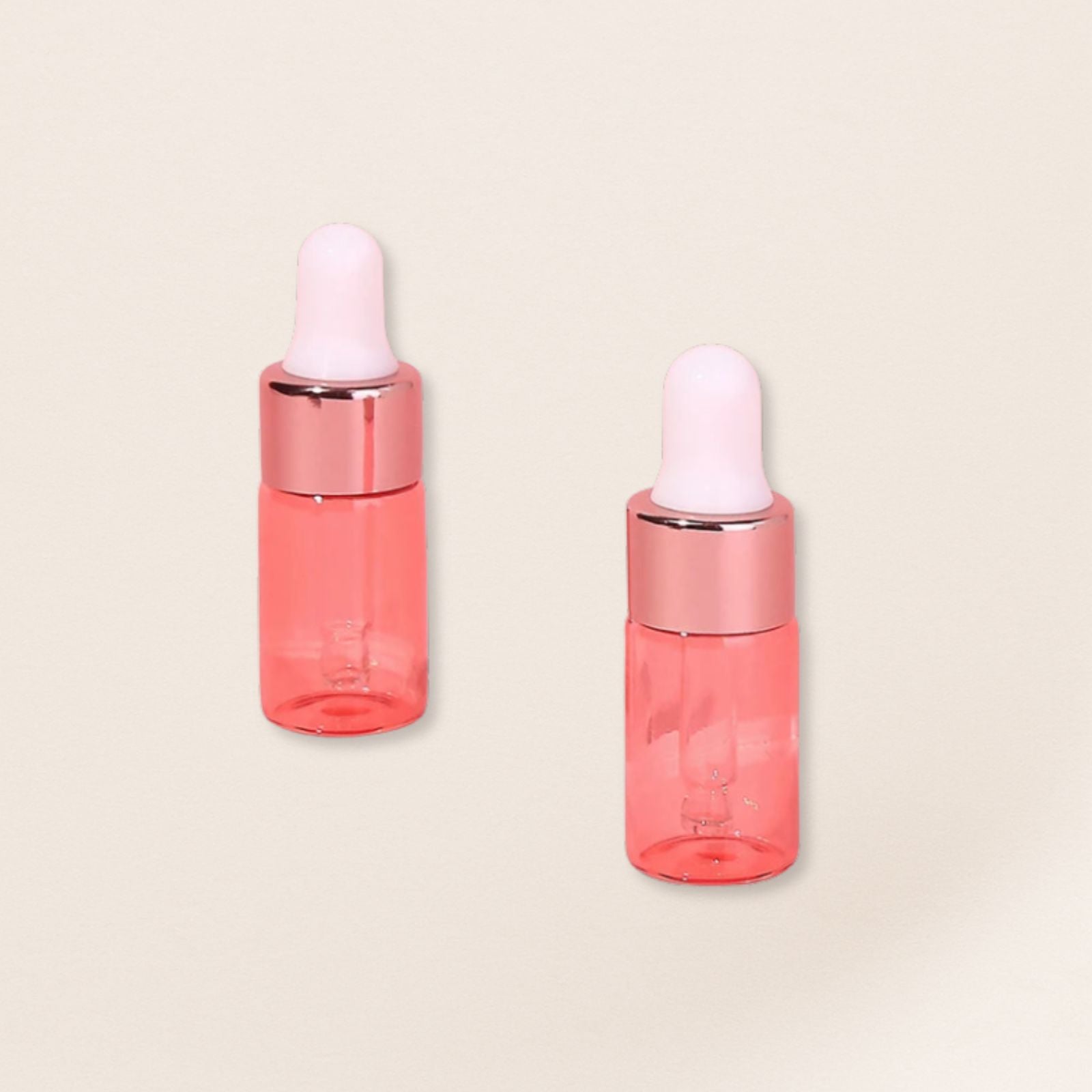 Two pink dropper bottles with white caps on a beige background