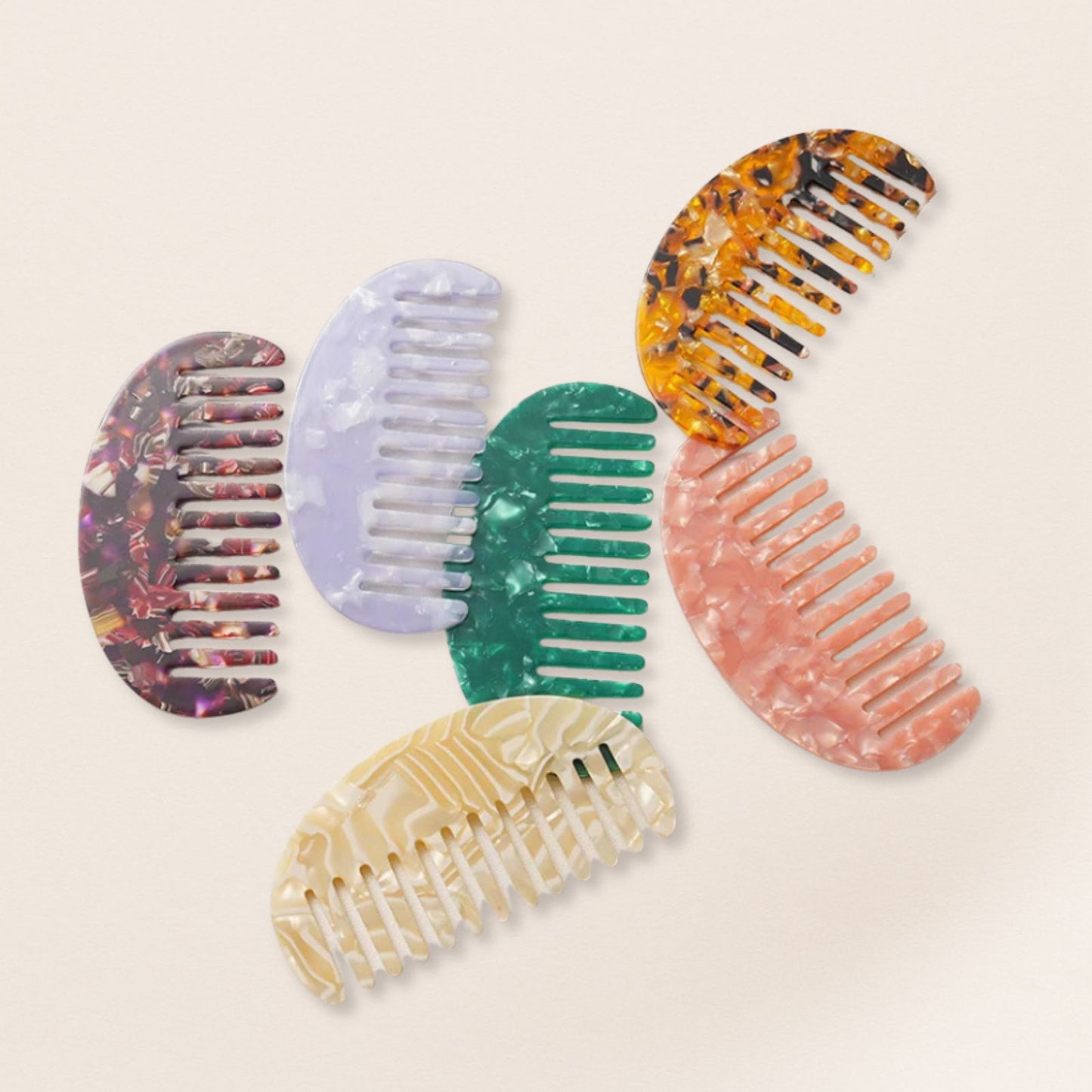 Lightweight marbled half-moon combs for fine hair on a beige background.