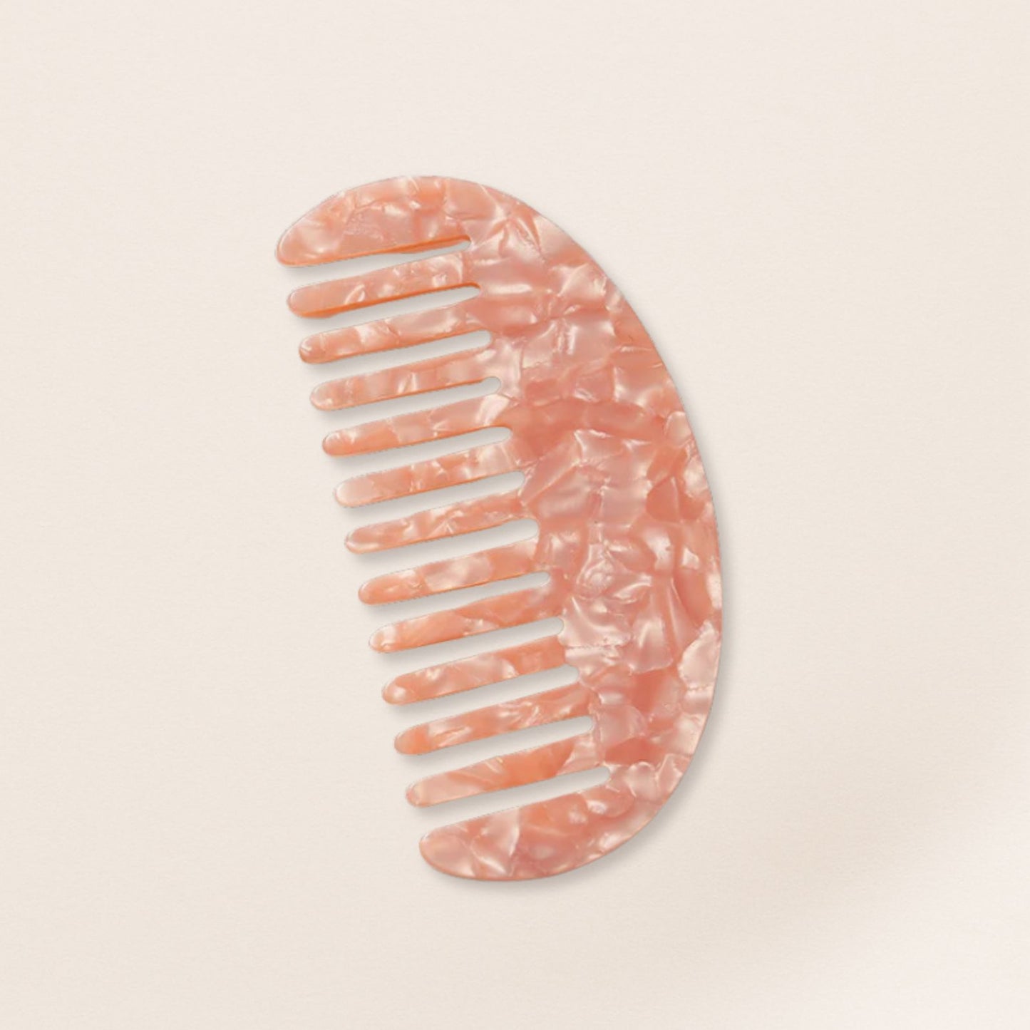Lightweight pink marbled half-moon comb for fine hair on a beige background.