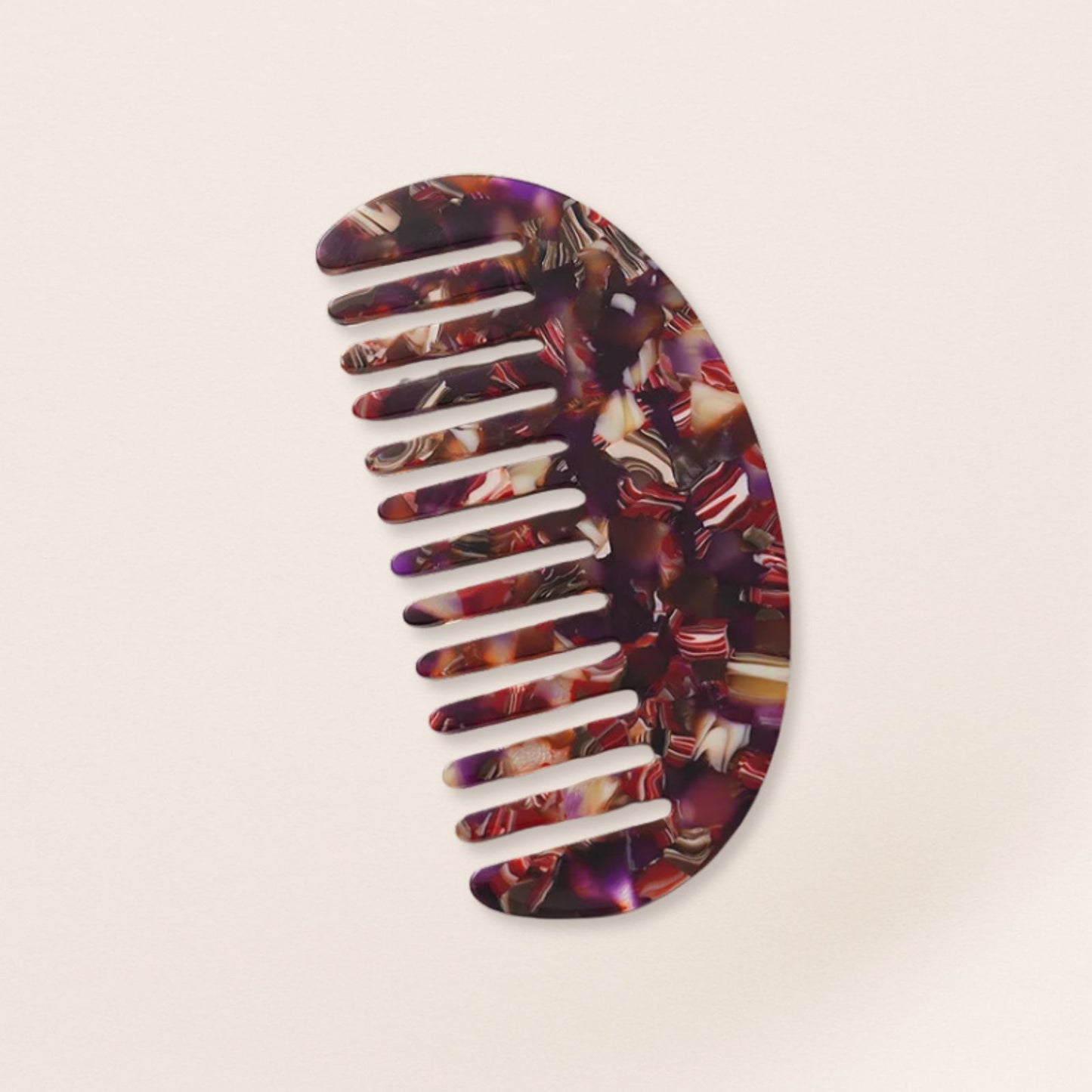 Lightweight purple marbled half-moon comb for fine hair on a beige background.