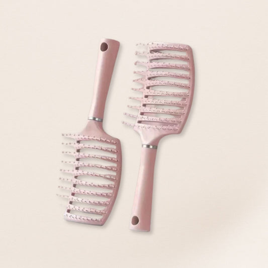 Two pink hairbrushes for fine hair with decorative patterns on a light beige background