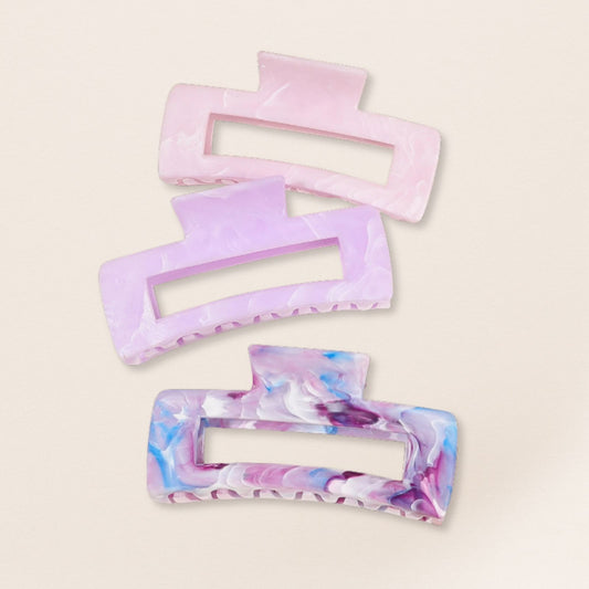 Set of three rectangular hair clips with marbled design on a beige background