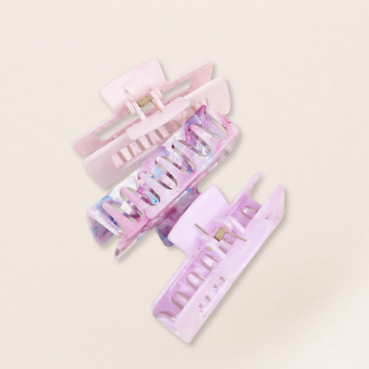 Set of three pastel-colored hair clips on a light beige background