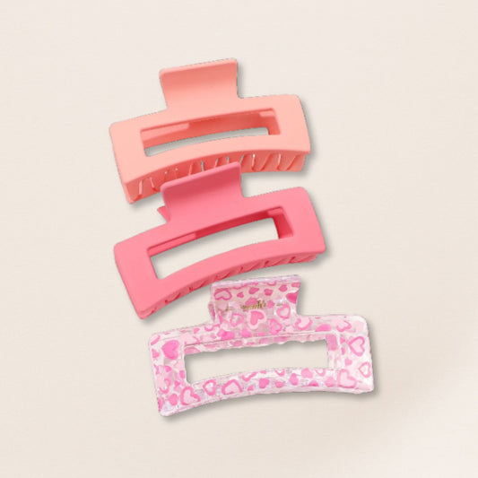 Set of pink hair clips on a beige background