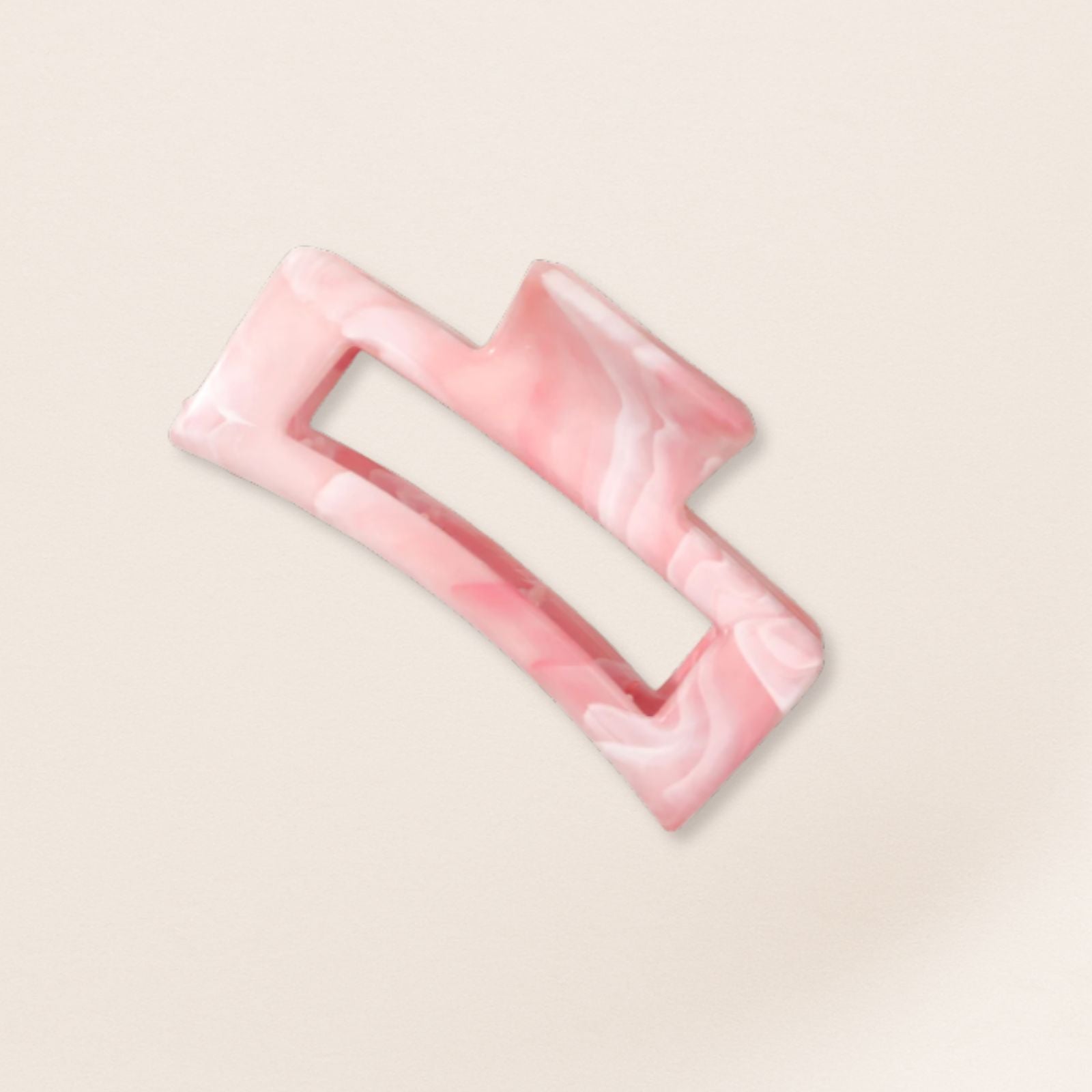 Pink rectangular hair clip for fine hair on a beige background