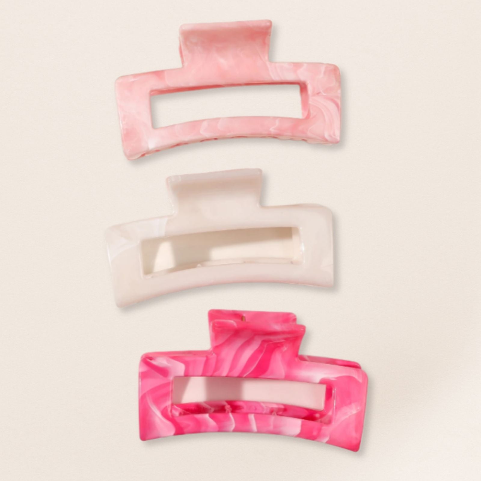 Three pink and beige hair clips for fine hair on a light beige background