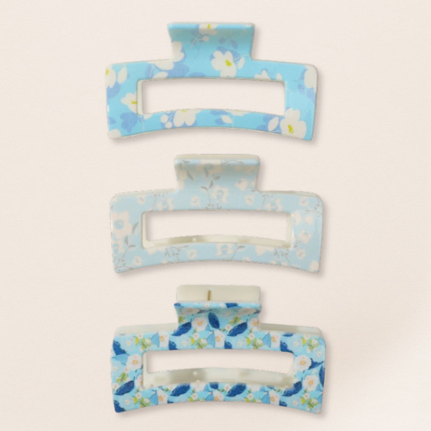 Set of three floral-patterned hair clips on a light beige background