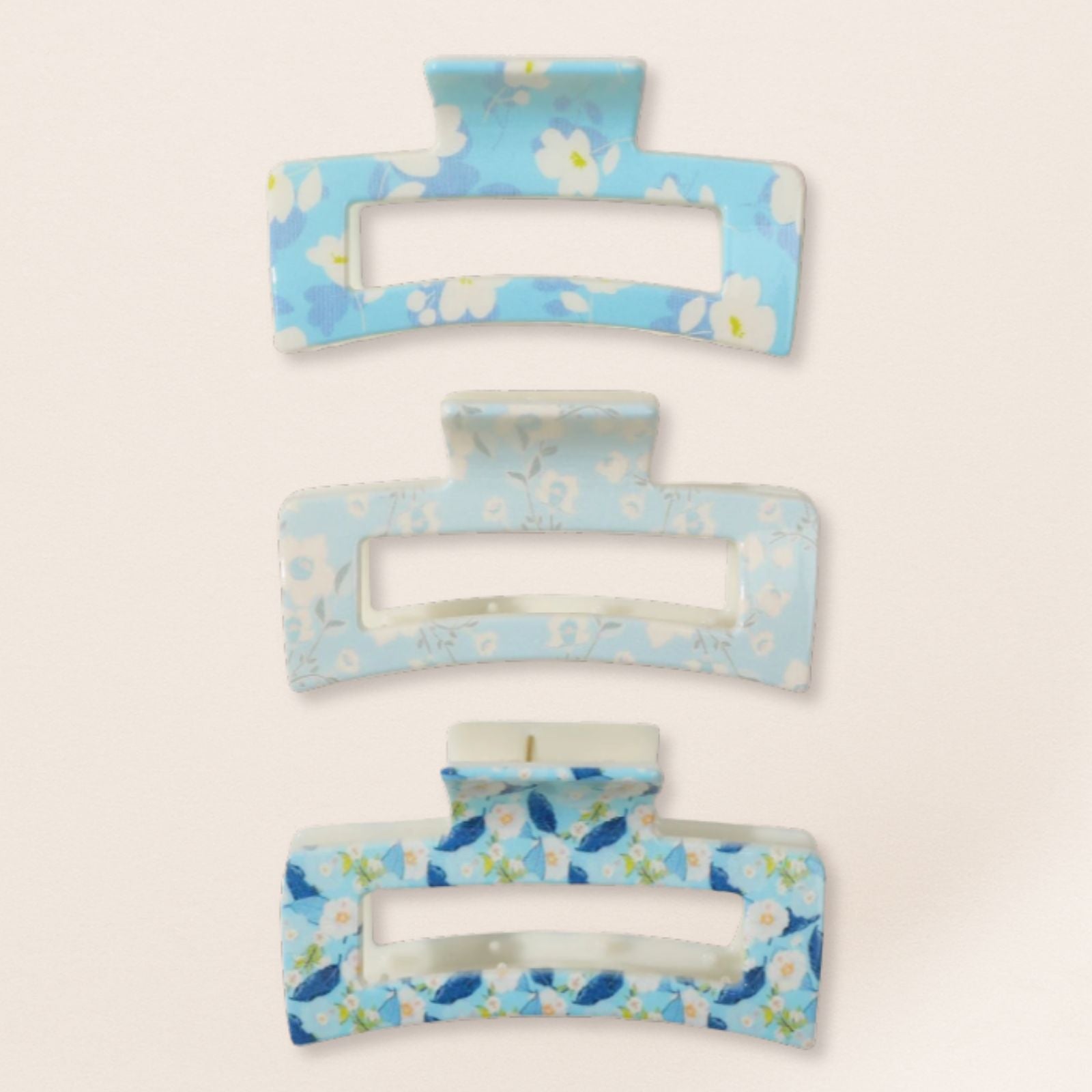 Set of three floral-patterned hair clips on a light beige background