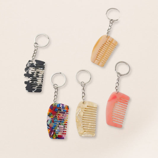 Set of five keychains shaped like hair accessories on a beige background