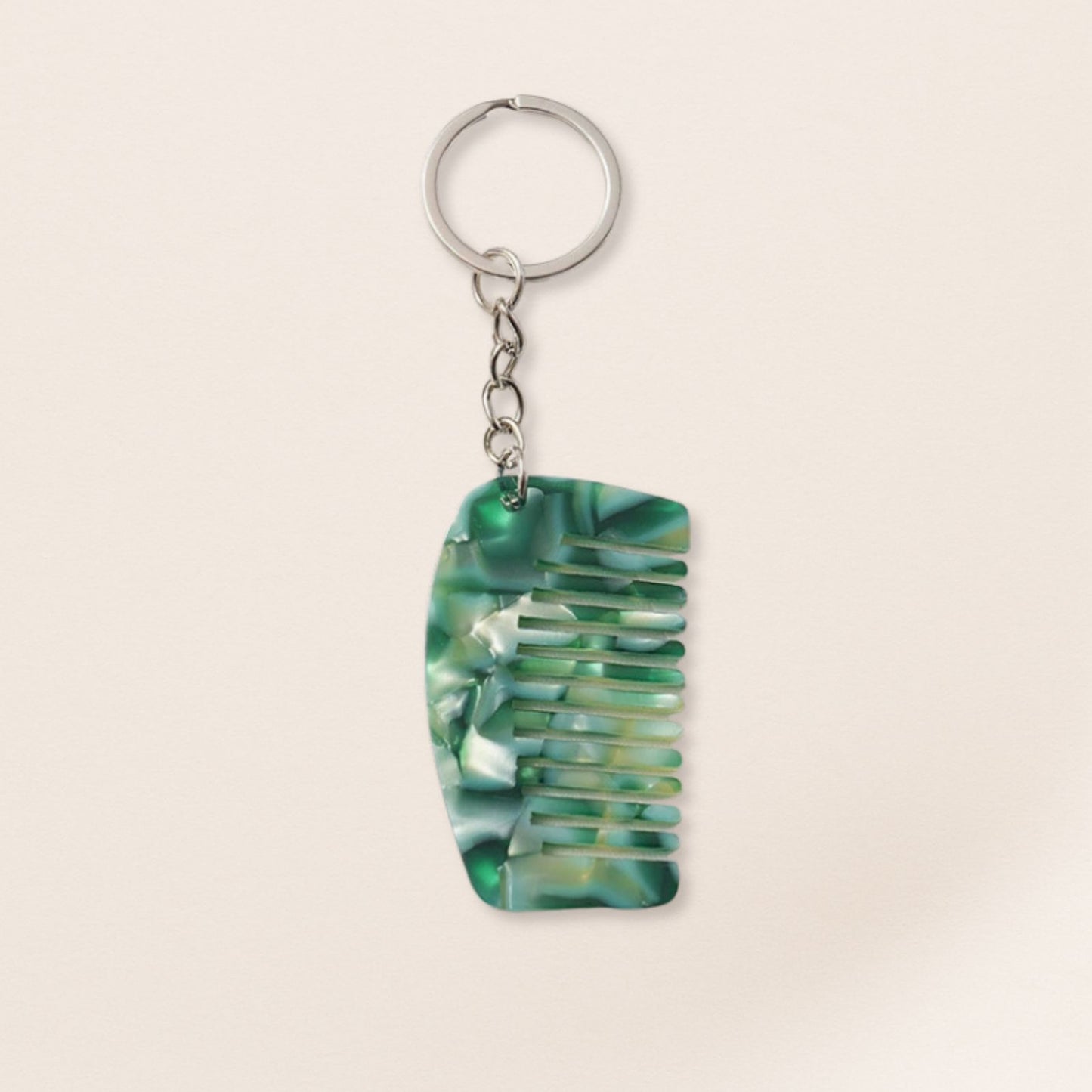 Green comb-shaped keychain on a beige background