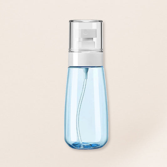 Blue spray bottle with a silver nozzle on a beige background