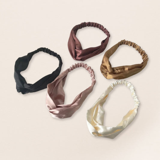 Five satin headbands in various colours on a beige background
