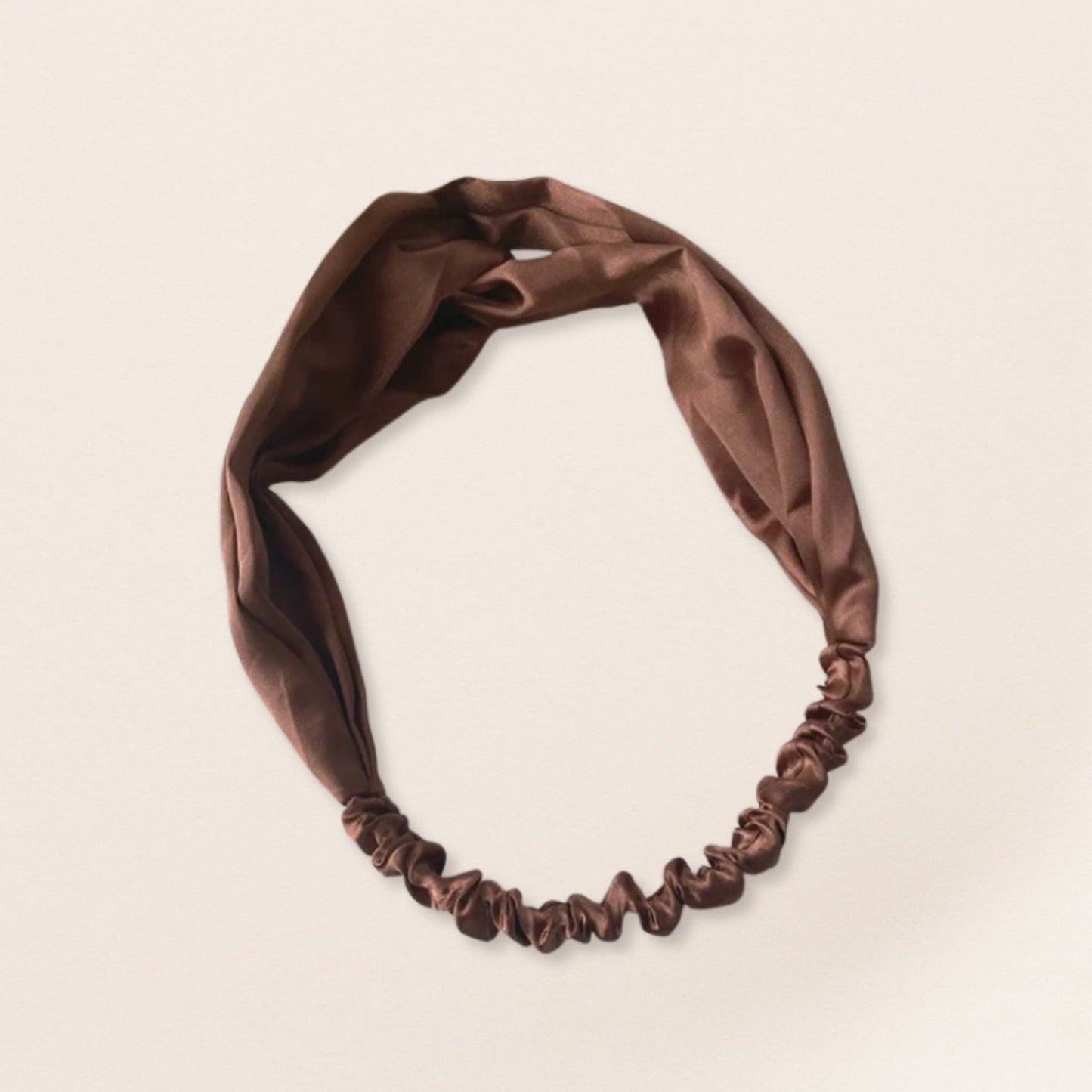Brown satin headband on a beige background