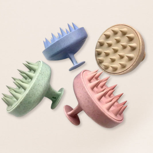 Four textured scalp massagers in different colors on a light background