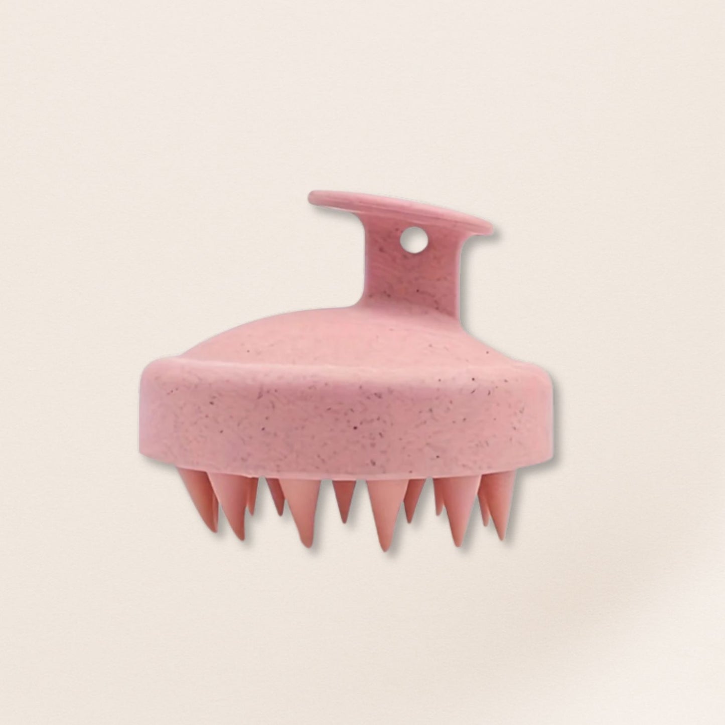Pink scalp massager on a beige background