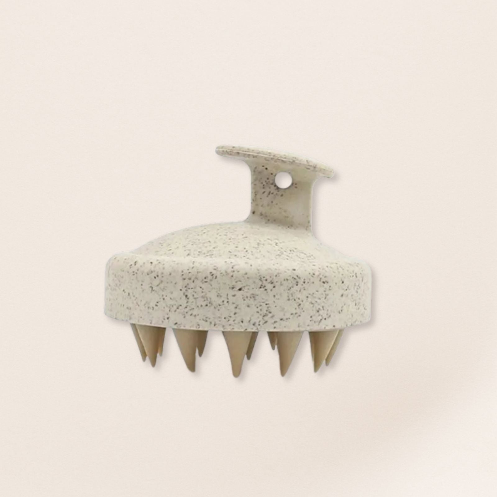 beige scalp massager on a beige background